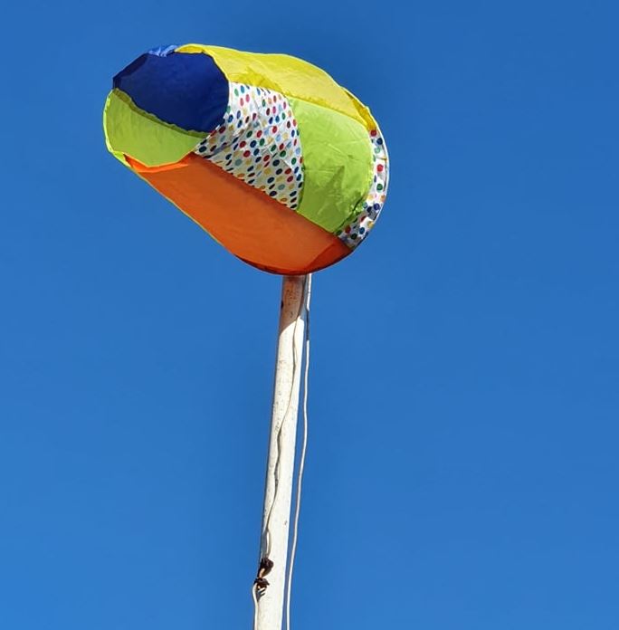 Windhose aus dem Stoff alter Regenschirme und Strandmuscheln genäht